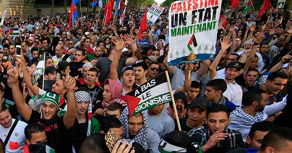 Palestine protesters hold up banners that read 