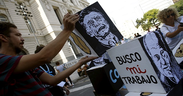 Employees of the Kirchner Cultural Center place cardboards depicting Argentine President Mauricio Macri.