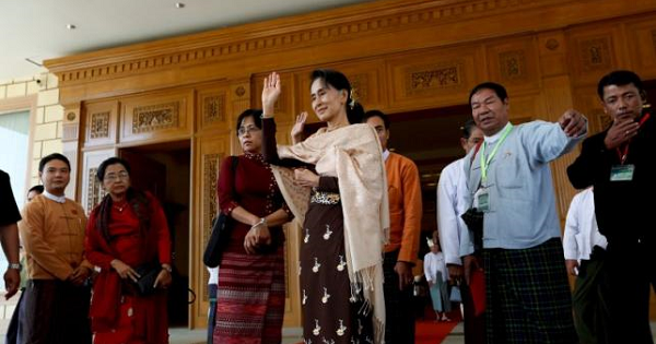 National League for Democracy party leader Aung San Suu Kyi waves to Shwe Mann as he leaves the Parliament in Naypyitaw, Jan. 29, 2016.