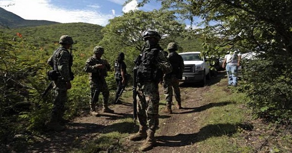 A soldier guards an area where a mass grave was found, in Colonia las Parotas on the outskirts of Iguala, in Guerrero October 4, 2014.