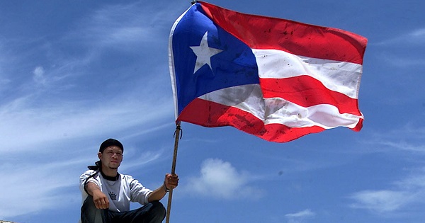 A Puerto Rican man holds up his nation's flag during a May Day event in Vieques, Puerto Rico, May 1, 2003.