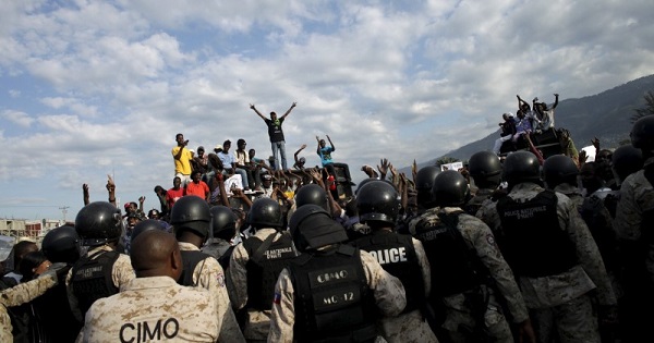 Protesters react behind a police cordon during a demonstration called up by opposition groups in Port-au-Prince, Haiti, February 4, 2016.