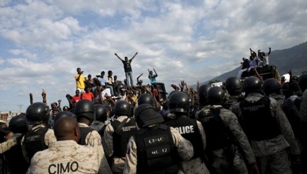 Protesters react behind a police cordon during a demonstration called up by opposition groups in Port-au-Prince, Haiti, February 4, 2016. 