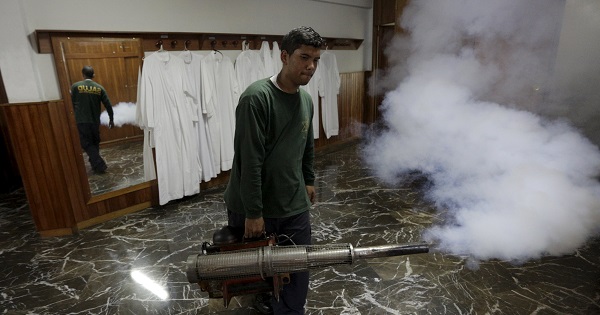 A municipal worker fumigates inside the parsonage of a church to help control the spread of the mosquito-borne Zika virus in Caracas.