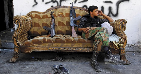 A Free Syrian Army fighter relaxes on a sofa in the old city of Aleppo, Syria.
