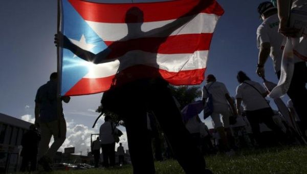 A protester holding a Puerto Rico's flag takes part in a march in San Juan