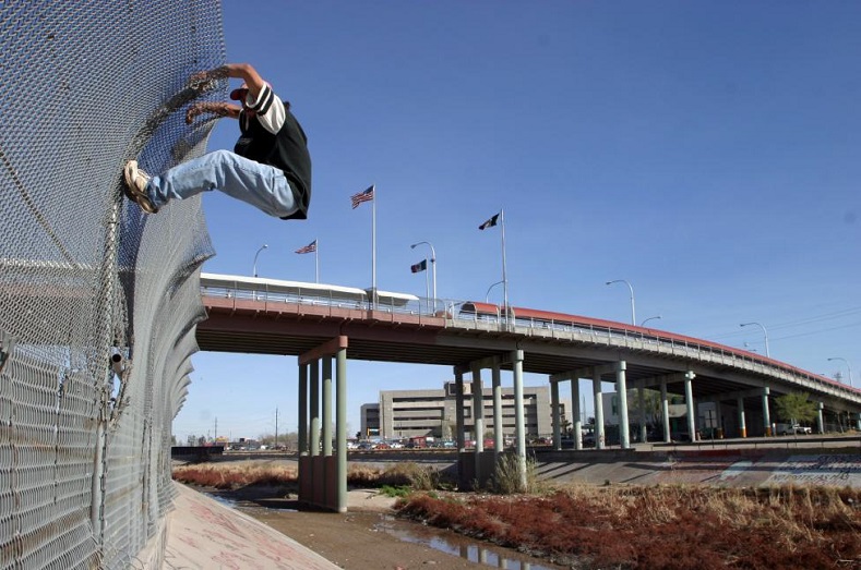 A migrant tries to cross into the U.S. from the Mexican border town of Ciudad Juarez, under the bridge that connects the border city with El Paso March 6, 2006.