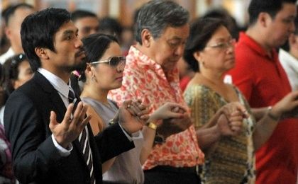 Philippine boxing hero Manny Pacquiao (L) holds his wife Jinkee's hand as they attend a mass at the Quiapo church in Manila.