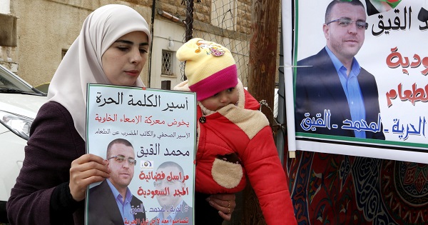 Wife of Mohammad al-Qeeq holds a picture of her husband in a protest tent near their house in West Bank town of Dura south of Hebron, Israel.