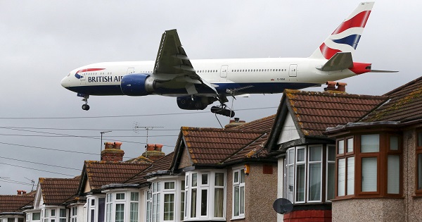 An aircraft passes over houses at it lands at Heathrow Airport near London, Britain, Dec. 11, 2015.