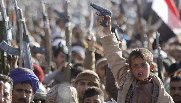 A boy shouts slogans as he raises a gun during a rally against U.S. support to Saudi-led air strikes, in Yemen's capital Sanaa, Feb. 19, 2016.