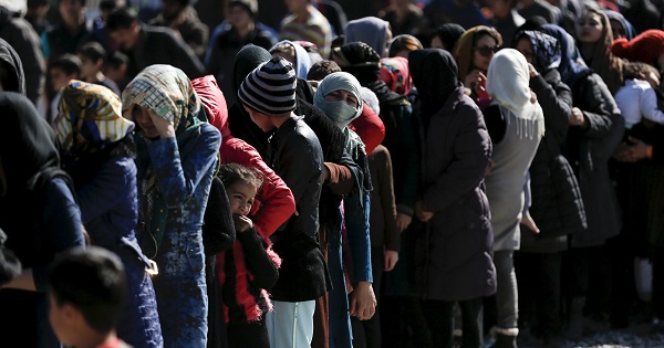Refugees and migrants line up for a food distribution at a relocation camp in Schisto, near Athens, Greece, Feb. 25, 2016.
