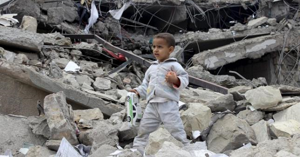 A boy walks as he collects toys from the rubble of a house destroyed by a recent air strike in Yemen's northwestern city of Saada May 27, 2015.