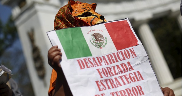 A demonstrator in Mexico City holds a sign that reads, 