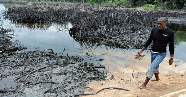 A man walks by a spill in the Niger Delta.