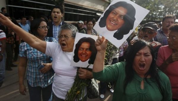 Activists hold photos of slain environmental rights activist Berta Caceres and shout after her body was released from the morgue in Tegucigalpa, March 3, 2016.