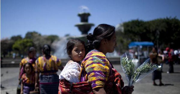 An Indigenous woman walks with her daughter after participating in the commemoration of International Women's Day today in the Central Park Guatemala city.