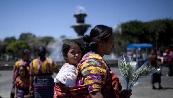 An Indigenous woman walks with her daughter after participating in the commemoration of International Women's Day today in the Central Park Guatemala city. 