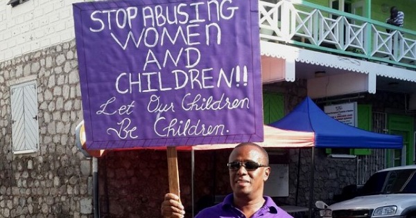 One purple-clad man stands in solidarity with women in Roseau, Dominica.