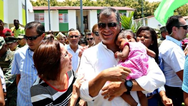 Ecuadorean President Correa greets a child as he tours a new social housing complex in the province of Esmeraldas, Ecuador, March 9, 2016.