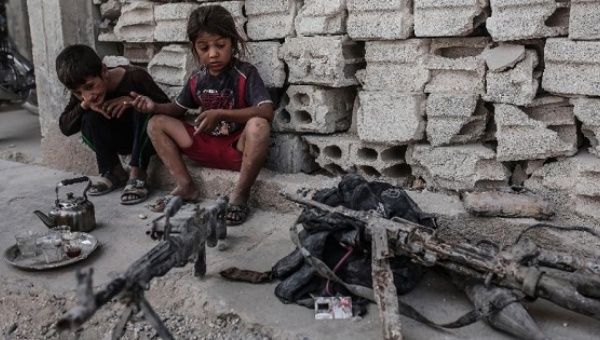 Children look at seized weapons from the Islamic State group on Sept. 6, 2015 in Kobane, northern Syria.