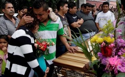 Relatives of a victim of the El Cambray mudline mourn next to his coffin at a cemetery on the outskirts of Guatemala City on Oct. 4, 2015.