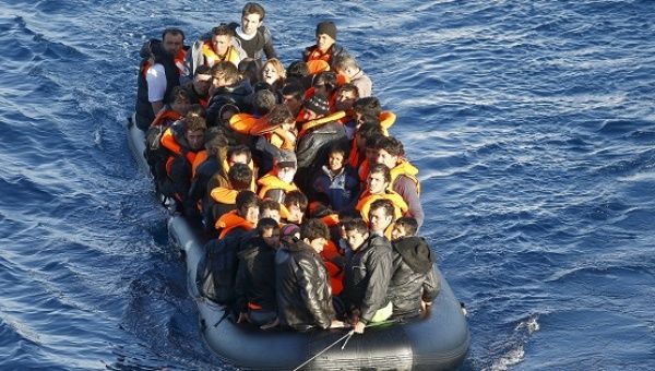 A dinghy of refugees and migrants is towed by a Turkish Coast Guard fast rigid-hulled inflatable boat on the Turkish territorial waters of the North Aegean Sea.