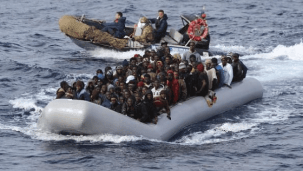 Migrants sit in a boat during a rescue operation by Italian navy off the coast of the south of the Italian island of Sicily in this Nov. 28, 2015.