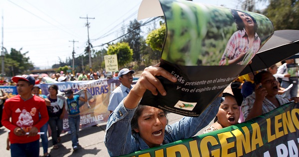 Indigenous woman holds a poster with a photograph of slain environmental rights activist Berta Caceres.