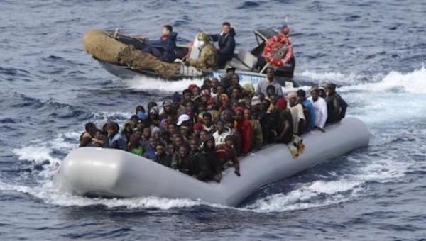 Migrants sit in a boat during a rescue operation by Italian navy off the coast of the south of the Italian island of Sicily in this November 28, 2013 picture provided by the Italian Marina Militare.