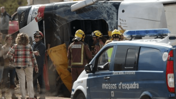 Firemen stands next to the wreckage of a bus after a traffic accident in Freginals, Spain, March 20, 2016.