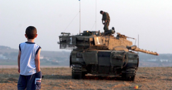 A child looks at an Israeli tank near Gaza, July, 2006. The International Criminal Court will consider Palestine's claim that Israel is guilty of war crimes.