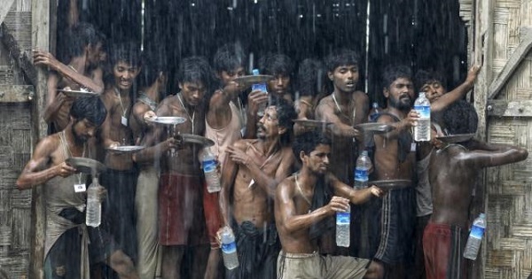 Migrants, who were found at sea on a boat, collect rainwater during a heavy rain fall at a temporary refugee camp near Kanyin Chaung jetty, outside Maungdaw township, northern Rakhine state, Myanmar June 4, 2015