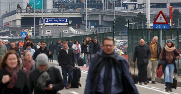 People leave the scene of explosions at Zaventem airport near Brussels, Belgium.