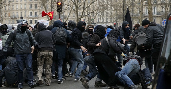 French high school and university students fall as they retreat while they take part in a demonstration against the labour reform bill proposal in Paris, France, March 24, 2016.