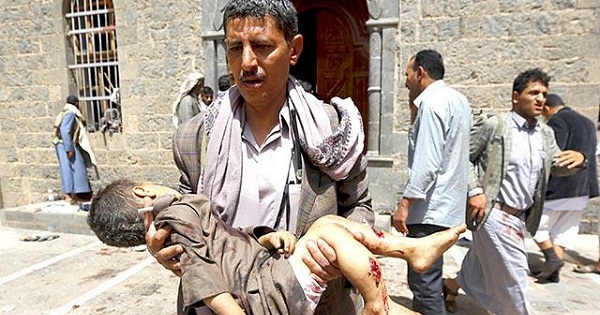 A man carries the body of a child out of the mosque which was attacked by a suicide bomber in Sanaa.