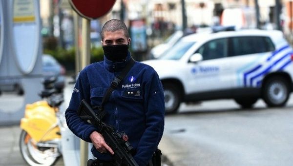 A Belgian police officer stands guard during an anti-terror raid in the Schaerbeek - Schaarbeek district of Brussels, on March 25, 2016.