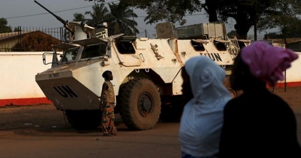 Women walk by a United Nations peacekeeping armoured vehicle  in the mostly Muslim PK5 neighborhood of Bangui, Central African Republic.