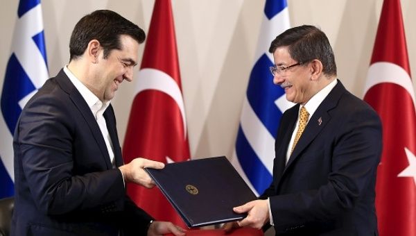 Turkish Prime Minister Ahmet Davutoglu (R) and his Greek counterpart Alexis Tsipras exchange agreements during a signing ceremony in the Aegean port city of Izmir, western Turkey, March 8, 2016.