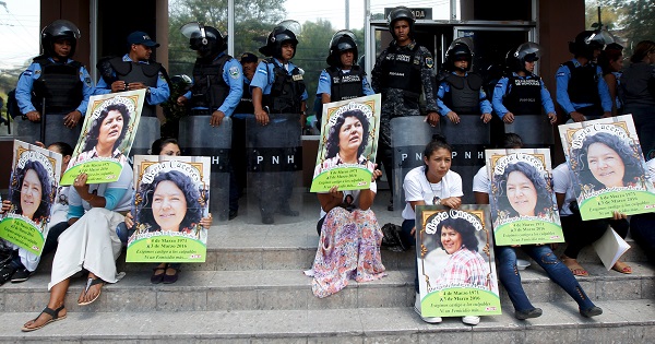 Indigenous people hold posters of Berta Caceres while sitting in front of riot police during a protest to demand justice in Tegucigalpa, Honduras, March 17, 2016.