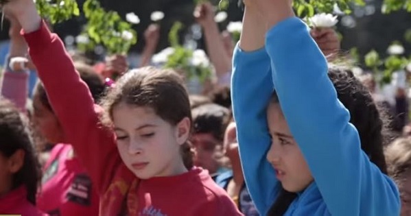 Refugee children at the Greek-Macedonian border carry flowers in protest of the closure of the Greek-Macedonian border.