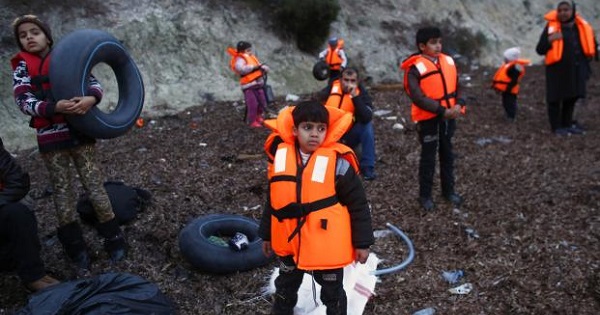 Migrant children wearing life jackets wait for a dinghy to sail off for the Greek island of Lesbos from the Turkish coastal town of Dikili, Turkey, April 6, 2016.