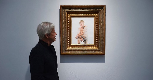 A gallery curator looks at a painting of U.S. presidential candidate Donald Trump titled 