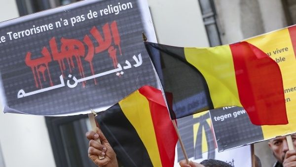 Members of the Muslim community in Belgium hold posters and flags during a ceremony for victims of last month's attacks in Brussels, Belgium, April 9, 2016.