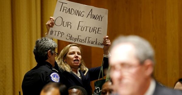 Police remove activist Margaret Flowers for protesting the Trans-Pacific Partnership during a Senate hearing in January 2016.