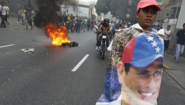  A man holds a poster of Henrique Capriles in protest of Maduro's election as president, April 2013.