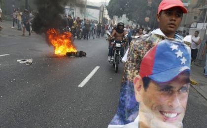  A man holds a poster of Henrique Capriles in protest of Maduro's election as president, April 2013.