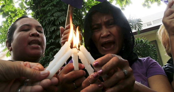 Activists light candles and offer prayers during a memorial ceremony in Manila.