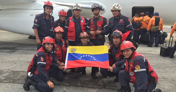 A Venezuelan rescue team poses for a photo as they prepare to board a plane to Ecuador to join rescue efforts after a massive earthquake, Sunday April 17, 2016.