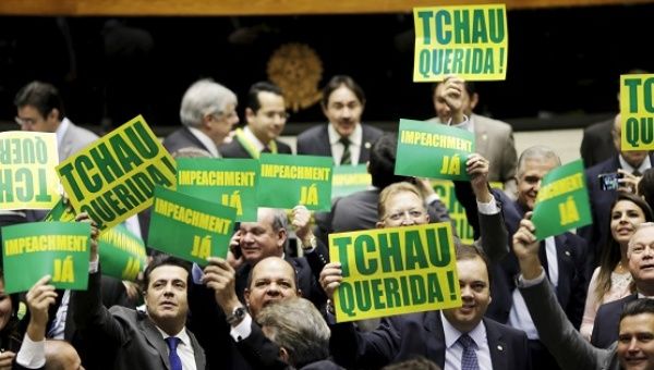 Members of Congress in support of Rousseff's impeachment hold placards reading 